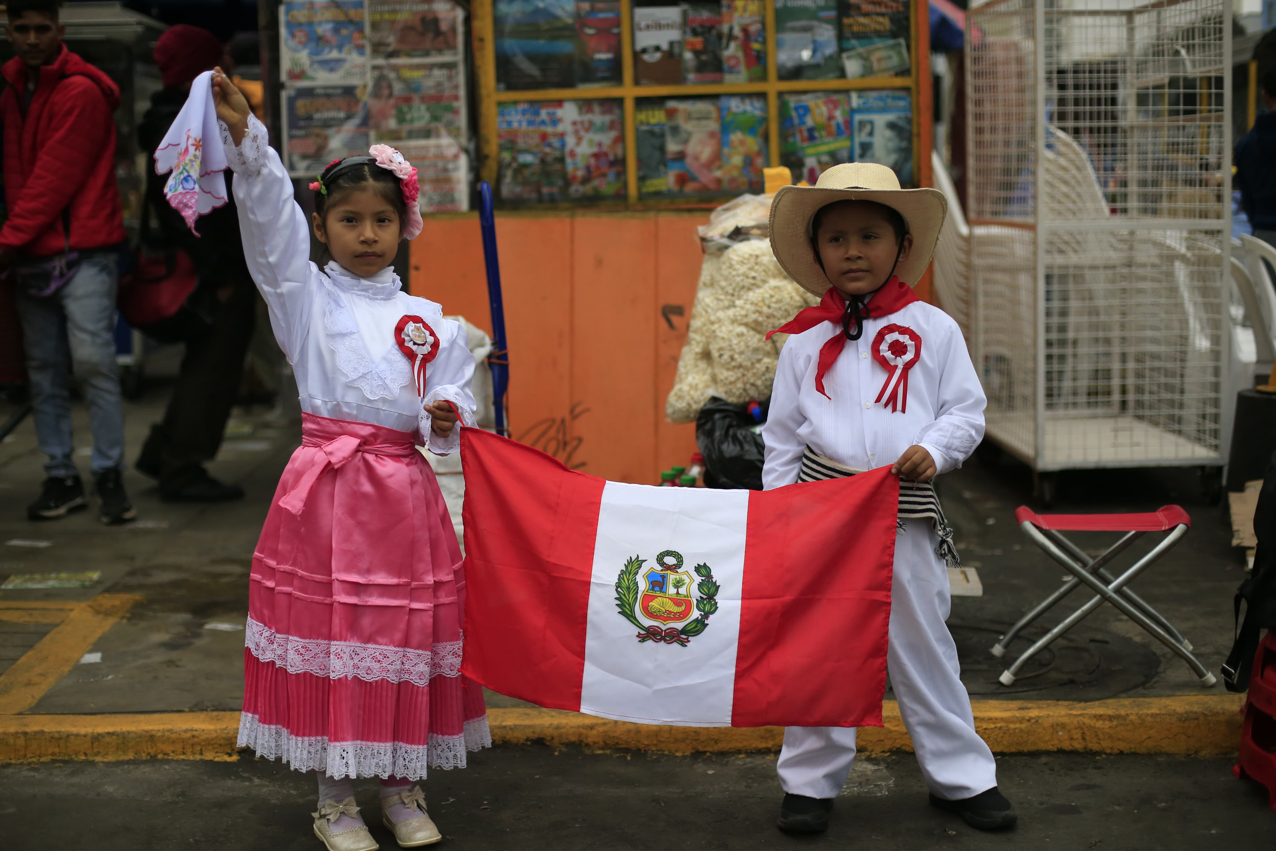  (10) AMOR POR LA PATRIA. Niños vestidos para bailar marinera posan con la bandera peruana.