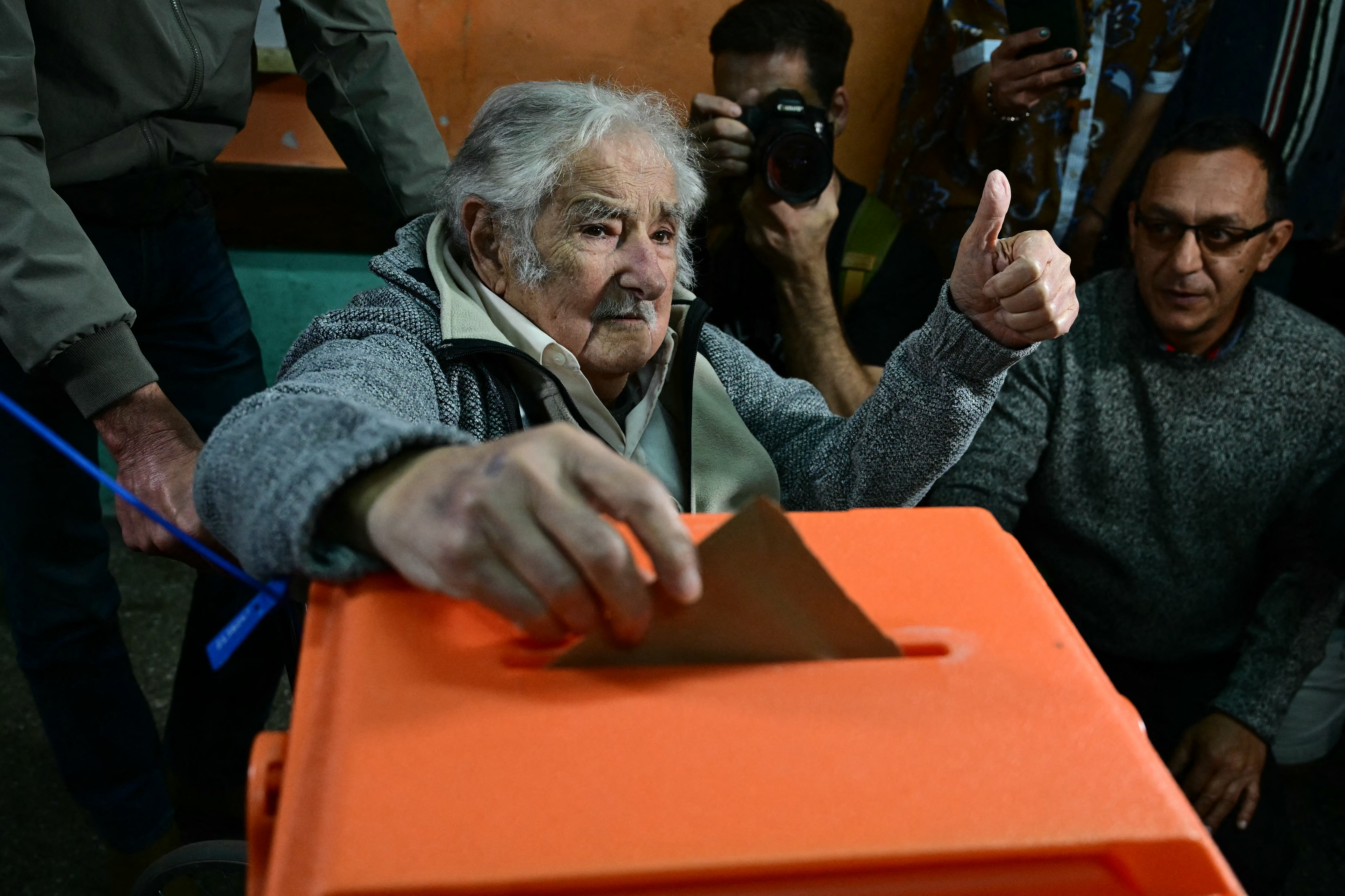 El expresidente uruguayo (2010-2015) José Mujica hace un gesto con el pulgar hacia arriba mientras emite su voto en un colegio electoral en Montevideo