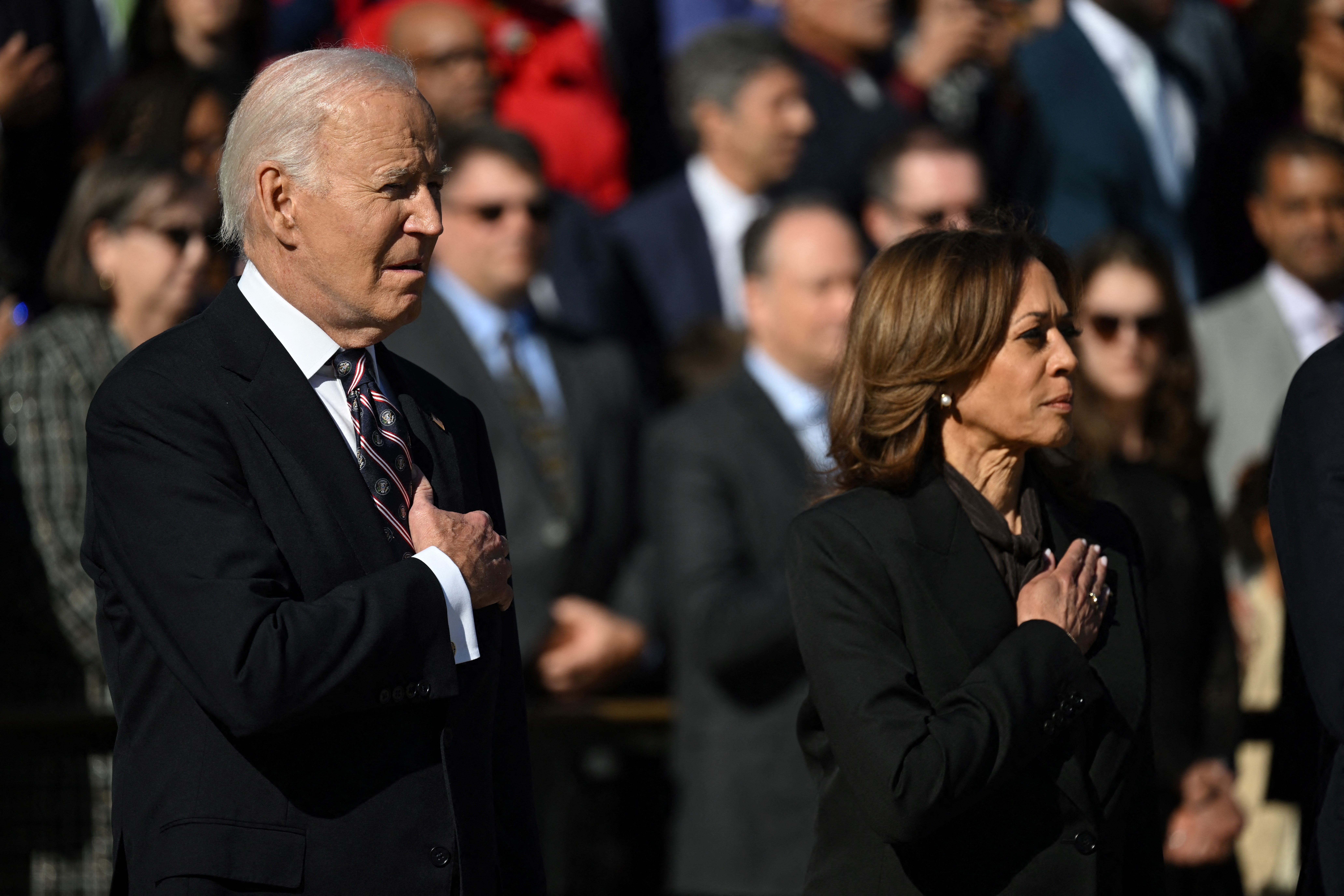 Biden y Harris, ambos vestidos con trajes oscuros, se pusieron las manos sobre el corazón antes de participar en una ceremonia oficial.