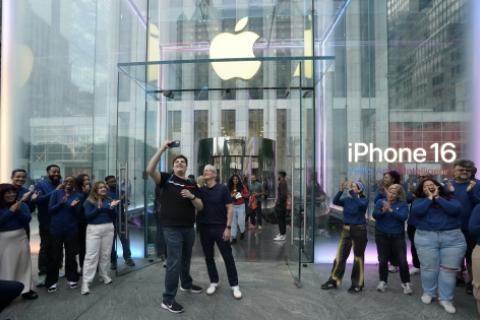 Apple CEO Tim Cook (C) poses for selfies with customers during Apple's iPhone 16 launch in New York on September 20, 2024. Apple on September 9, 2024 announced a new iPhone built for generative artificial intelligence as it seeks to boost sales and show it is keeping up in the technology race. (Photo by TIMOTHY A. CLARY / AFP)