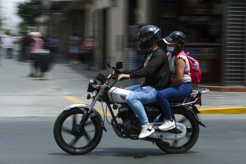 Dos personas transitando en moto lineal por la ciudad