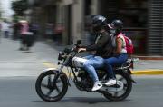 Dos personas transitando en moto lineal por la ciudad